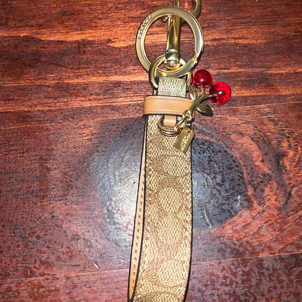 Coach Signature Cherry Loop Key Ring in gold and khaki with red cherry accents